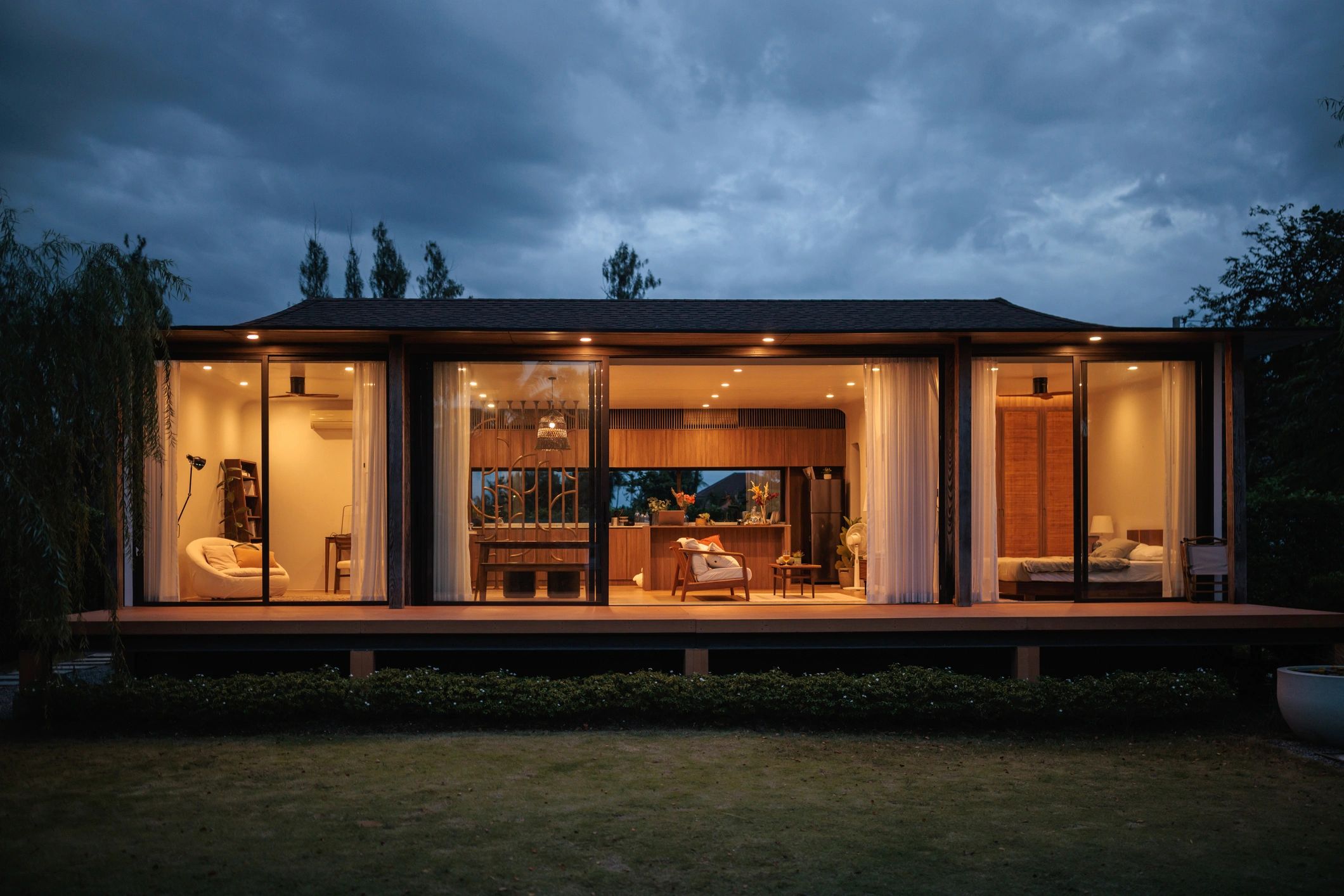Inviting coastal-style home with a welcoming porch lit at dusk